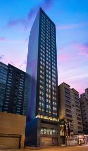 un grand bâtiment avec une peinture sur son côté dans l'établissement Hotel Purple Hong Kong, à Hong Kong