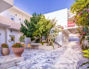 a courtyard with a table and chairs and plants at VILLA SELINI LUXURY APARTMENT in Matala