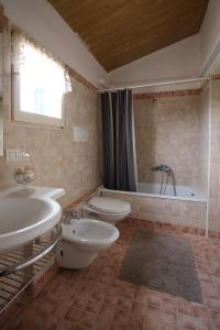 uma casa de banho com 2 lavatórios, um WC e uma banheira em Casa S.Paolo em Rimini