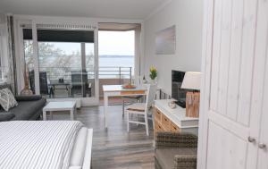 Zimmer mit einem Bett und einem Wohnzimmer mit einem Tisch in der Unterkunft Inselblick am Meer in Glücksburg