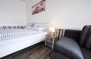 グリュックスブルクにあるInselblick am Meerのベッドルーム1室(ベッド1台、ソファ、椅子付)