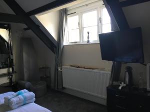 Cherrywood Lodge في لوي: غرفة نوم بها سرير وتلفزيون ونافذة