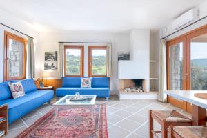 a living room with a blue couch and a fireplace at Villa Almira Luxury Apartments in Ouranoupoli