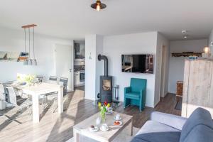 Landgang في أوبلينتيز: غرفة معيشة مع أريكة زرقاء وموقد