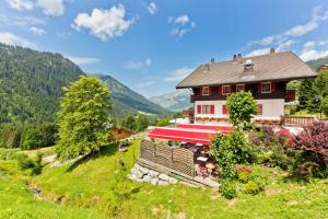 ein Haus mit rotem Dach auf einem Hügel in der Unterkunft Le Roitelet in Châtel