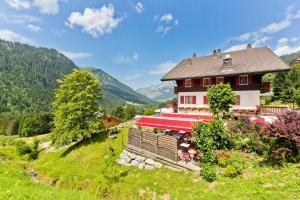 a house with a red roof sitting on a hill at Le Roitelet in Châtel