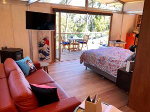 a living room with a couch and a bed at Free Spirit Pods in Barnes Bay