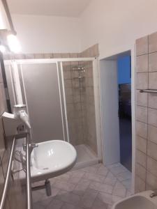 een badkamer met een douche en een witte wastafel bij Alloggio Cantalupo in Formigine