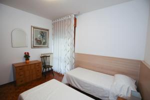 a bedroom with two beds and a dresser and a window at Appartamento Martina C. in Marghera