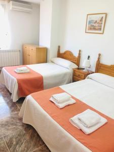 a hotel room with two beds with towels on them at Hostal Restaurante Taibilla in Nerpio +66 photos
