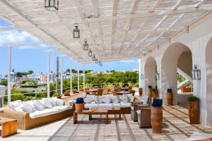 a patio with couches and tables on a building at Approdo Boutique Hotel Leuca in Leuca