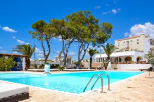 a swimming pool with palm trees and a building at Approdo Boutique Hotel Leuca in Leuca