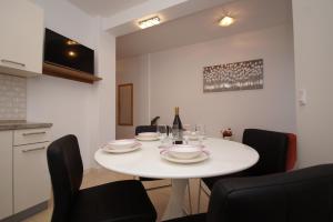 a white table with plates and wine glasses on it at Apartments Mirna in Korčula