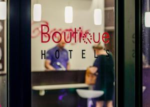 un reflejo de un hombre en un escaparate en Boutique Hotel's III en Lodz