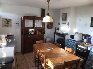 a kitchen with a wooden table and a kitchen with a microwave at Gite a la campagne in Sardent