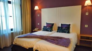 a bedroom with a large bed with purple walls at Hotel Bliss in Bruges