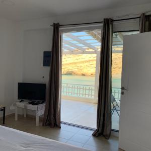a bedroom with a large window with a view of the ocean at Bella Vista Luxury Apartment in Matala