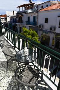 un tavolo e sedie seduti su un balcone di Albertoshouse a Città di Skiathos