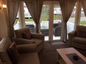 a living room with two couches and a balcony at Neecee’s Retreat in Tattershall