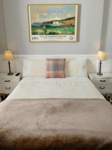 a bedroom with a white bed with two nightstands and two lamps at Malvern House in Portrush +22 photos