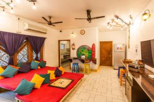 a living room with a large red bed with colorful pillows at goSTOPS Varanasi in Varanasi