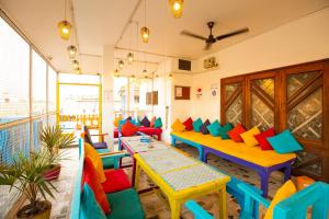 a restaurant with colorful tables and chairs in a room at goSTOPS Varanasi - Rooms & Dorms in Varanasi