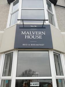 a building with a sign for a marven house bed and breakfast at Malvern House in Portrush