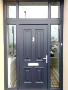 uma porta da frente azul com uma janela em Malvern House em Portrush