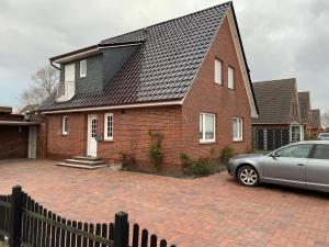 a house with a car parked in front of it at Pension Julia 2 in Norden