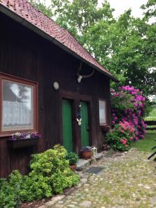 a house with a green door and some flowers at Reiterhof Winandy in Wietzendorf