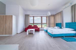 a bedroom with two beds and a red couch at Apartamenty Mazury Golf & Country Club in Naterki