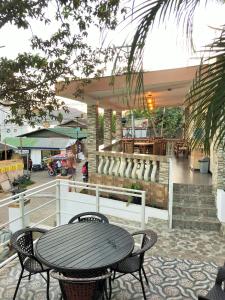 une table et des chaises assises devant un bâtiment dans l'établissement Dignadice's Homestay, à Coron