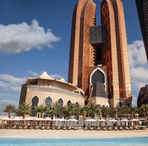 un complejo con sillas y sombrillas en la playa en Bab Al Qasr Hotel, en Abu Dabi