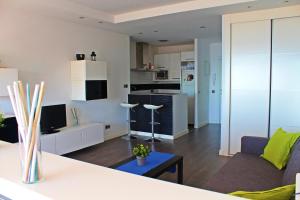 a living room with a couch and a kitchen at Beach Apartment Guadalmar in Málaga