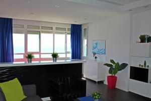 - un salon avec un comptoir et des rideaux bleus dans l'établissement Beach Apartment Guadalmar, à Malaga