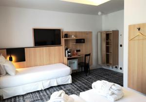a hotel room with two beds and a flat screen tv at Libertel Gare Du Nord Suede in Paris