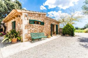 a stone house with a bench in front of it at Finca Agroturismo Sa Cova den Borino in Campos