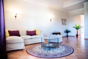 a living room with a white couch and a glass table at Colina Verde Resort in Moncarapacho