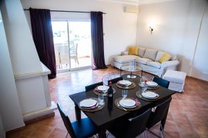 a living room with a black table and chairs at Colina Verde Resort in Moncarapacho