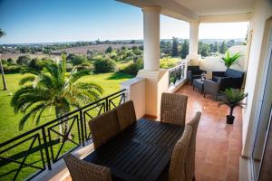 a balcony with a table and chairs and a view at Colina Verde Resort in Moncarapacho