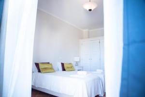 a bedroom with a white bed with yellow pillows at Colina Verde Resort in Moncarapacho