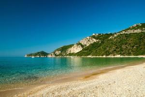 a beach with a rocky shore and the ocean at Patras Roof apartment in Agios Georgios Pagon +3 photos