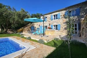 a stone house with a swimming pool and an umbrella at Villa Lemon in Vir