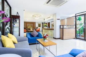 Lasalle Suites Hotel & Residence في بانكوك: غرفة معيشة مع أرائك زرقاء وطاولة