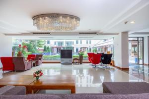 Lasalle Suites Hotel & Residence في بانكوك: غرفة معيشة فيها كراسي حمراء وثريا