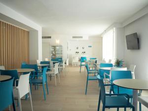 a dining room with tables and blue chairs at BLUESEA Costa Verde in El Arenal