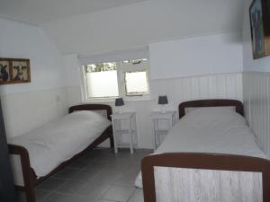 two beds in a small room with two windows at Buitengoed Het Achterdiep in Ter Apel