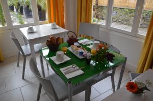 mesa de comedor con mesa verde y sillas en Hotel le Castellamar en Sainte-Maxime