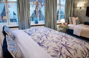 a bedroom with a bed and a couch and windows at Hotel Estheréa in Amsterdam