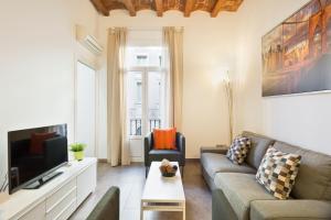 uma sala de estar com um sofá e uma televisão em Stay U-nique Apartments Eixample Center em Barcelona